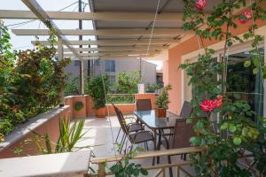 科孚镇Corfu Villa Potamaki的阳台配有桌椅和植物
