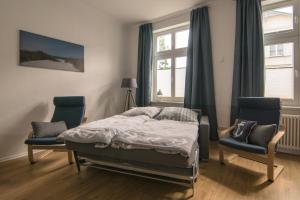 施特拉尔松德Ferienwohnung Sundkieker的一间卧室配有一张床、两把椅子和一个窗户