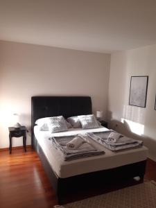 莫斯塔尔西娅公寓酒店的一间卧室配有一张大床和黑色床头板
