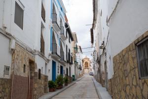 Urrea de GaenCasa Rural La Casona的一条狭窄的小巷,有白色的建筑和植物