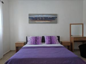 乌尔齐尼Beni Bungalows的一间卧室配有紫色床和紫色枕头