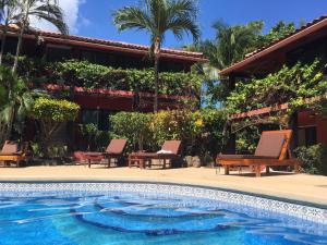 普拉亚弗拉明戈马萨伊公寓酒店的棕榈树屋前的游泳池