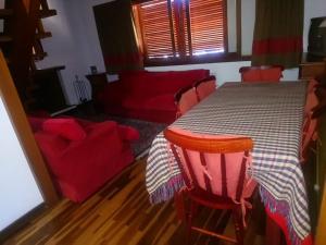 坎波斯杜若尔当Apartamento no Centro de Campos do Jordao的一张带红色椅子和红色沙发的餐桌