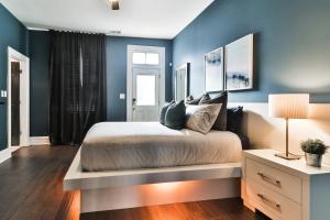 马里兰高地Luxury Apt w/ Spectrum Mood Lighting - Historic Cherokee Street Antique Row的一间卧室设有蓝色的墙壁和一张带桌子的床