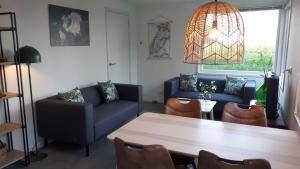 登堡Bungalow Groen的客厅配有蓝色的沙发和桌子