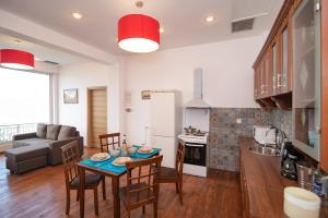 瓦西Calypso Apartments的厨房以及带桌椅的起居室。