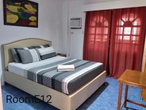 长滩岛Eriko's House的一间卧室配有床和红色窗帘