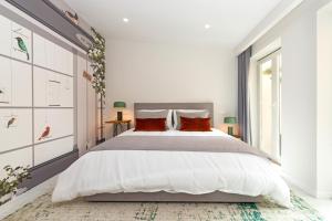 卡斯卡伊斯Bela Vista Palace Apartments的白色卧室配有一张带红色枕头的大床