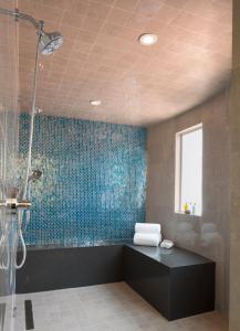 洛杉矶日落侯爵酒店的带淋浴的浴室(带蓝色瓷砖墙)