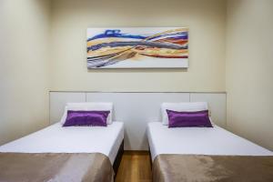 新加坡Hotel 81 Cosy的墙上画画的房间里设有两张床