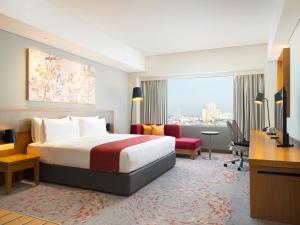 雅加达Holiday Inn & Suites Jakarta Gajah Mada, an IHG Hotel的配有一张床和一张书桌的酒店客房