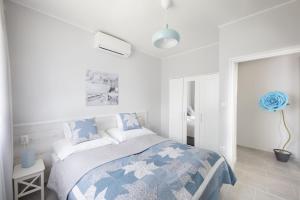鲍洛通费尼韦什TópART Apartman II的一间卧室配有一张带蓝白色毯子的床