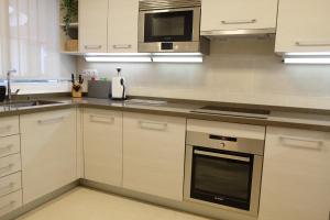 马贝拉luxury modern apartment with terrace, pool and garage!的厨房配有白色橱柜和炉灶烤箱。