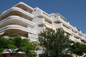 马贝拉luxury modern apartment with terrace, pool and garage!的前方有树木的白色公寓大楼