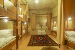 格雷梅Homestay Cave Hostel的小房间设有两张床和地毯