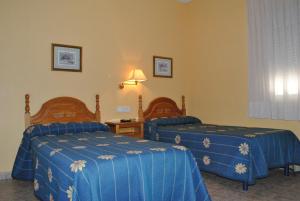 奥里韦拉雷伊提奥多汨罗旅馆的酒店客房,配有两张带蓝色床单的床