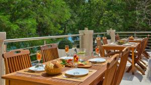 斯克拉丁Scardona Park Luxury Accommodation的木桌,甲板上摆放着食物和饮料