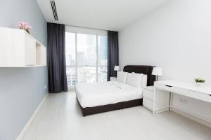 吉隆坡Binjai 8 KLCC by PSM Luxury Suites的白色卧室配有床和书桌
