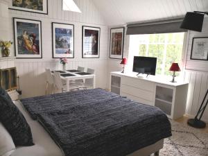 万塔Lovely Mint Garden Studio的一间卧室配有一张床、一张书桌和一台电视