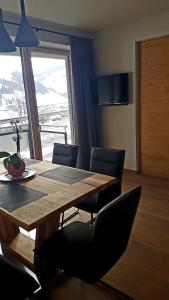 萨尔巴赫Appartement Mountainview的一间带桌椅和窗户的用餐室