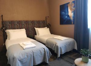 利加特内Zeit Hotel的一间设有两张床铺和毛巾的房间