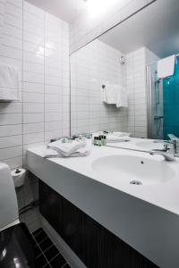 厄勒布鲁厄勒布鲁城市酒店的白色的浴室设有水槽和镜子