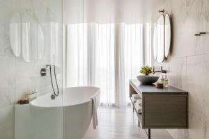 伦敦The Stratford Hotel London的白色的浴室设有浴缸和水槽。
