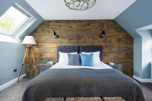 奥本The Kilchrenan Inn的一间卧室设有一张带木墙的大床