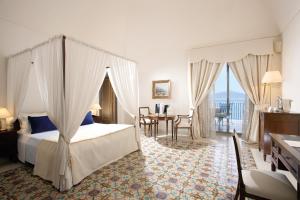 维克艾库塞安久丽列里大酒店的一间卧室配有天蓬床和桌椅