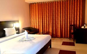 瓦拉纳西城市客栈酒店的一间卧室设有一张床和一个大窗户