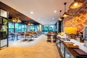 曼谷曼谷叻抛利沃特尔酒店的一间带桌椅的餐厅以及砖墙