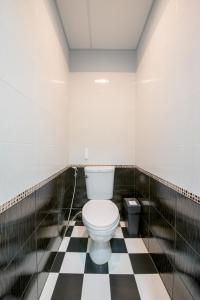 芭堤雅市中心辛迪旅舍的一间位于黑白格子地板上的浴室,配有厕所