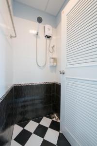 芭堤雅市中心辛迪旅舍的带淋浴的浴室以及黑白格子地板。