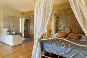 博比奥Relais SANT'AMBROGIO的一间卧室设有一张床和石墙