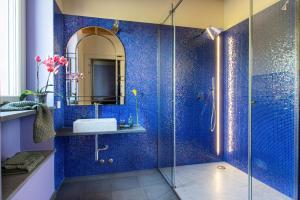 博比奥Relais SANT'AMBROGIO的蓝色瓷砖浴室设有水槽和淋浴