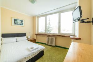 索波特Sopocki Zdrój的一间卧室配有一张床和一台平面电视