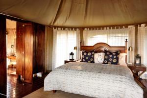 赫卢赫卢韦桑达游猎山林小屋的一间卧室配有一张带天蓬的大床