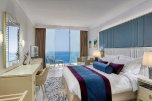 帕福斯Amavi, MadeForTwo Hotels - Paphos的酒店客房设有一张大床和一张书桌。