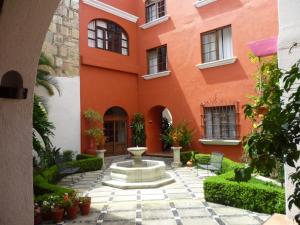 瓦哈卡市特雷沃尔酒店的一座橙色的建筑,庭院里设有喷泉