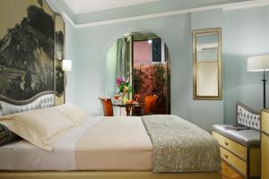 热那亚萨沃亚大酒店的一间卧室配有一张床、一把椅子和镜子