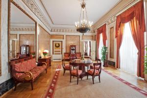 克拉科夫格兰德酒店的客厅配有桌椅和吊灯。
