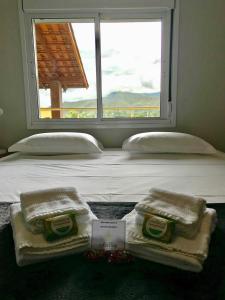 戈亚斯州上帕莱索Vila dos Cristais的一张带毛巾的床和窗户