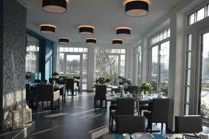 霍鲁梅尔希尔Hotel Garni Nordseejuwel的用餐室设有桌椅和窗户。