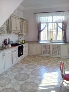 扎托卡Дом на берегу Черного Моря的一间厨房,配有白色的橱柜和大窗户
