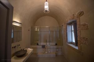 ÉrimosIPPOLA BOUTIQUE HOTEL的一间带水槽和玻璃淋浴的浴室