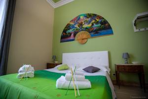 卡塔尼亚Sicily Luxury B&B的一间卧室配有带绿色床单和毛巾的床。