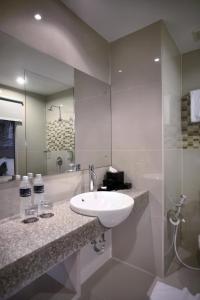 三宝垄Hotel Neo Candi Simpang Lima - Semarang by ASTON的浴室设有白色水槽和镜子