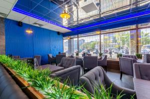 基辅旅游度假酒店的餐厅拥有蓝色的墙壁和椅子,种有植物