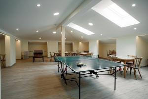 伦韦格Mühlbacherhof的配有桌椅的客房内的乒乓球桌