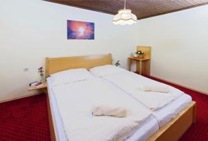 圣卡尼兹Bungalows Angelika am Klopeinersee Turnersee的一间卧室配有一张带白色床单的大床